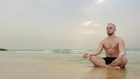 Man doing yoga on the beach by the sea Stock Footage 262003011