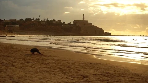 Man doing yoga on an empty sunset beach Stock Footage 82704090