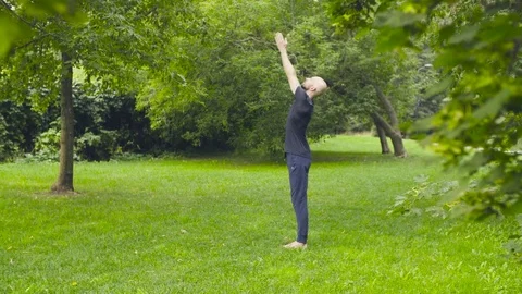 A man doing yoga exercises in the park Stock Footage 79393817