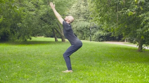 A man doing yoga exercises in the park Stock Footage