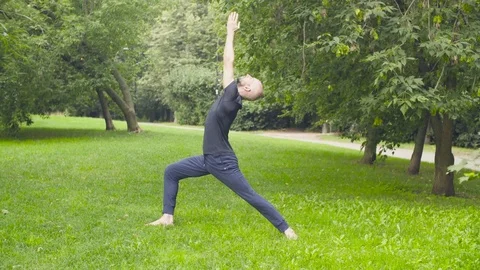 A man doing yoga exercises in the park Stock Footage