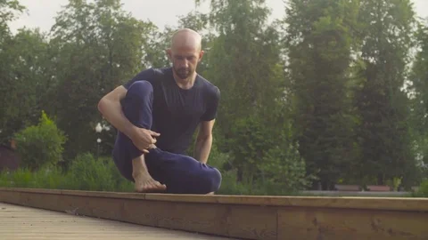 A man doing yoga exercises in the park Stock Footage 79403009