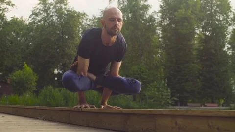 A man doing yoga exercises in the park Stock Footage