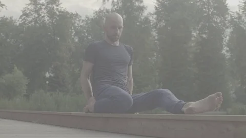 A man doing yoga exercises in the park Stock Footage