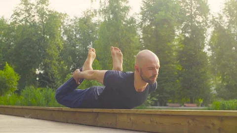 A man doing yoga exercises in the park Video stock 79539243