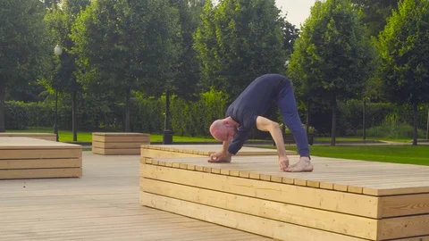 A man doing yoga exercises in the park Video stock 79539603