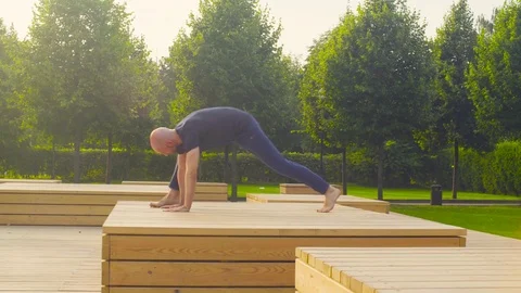A man doing yoga exercises in the park Stock Footage
