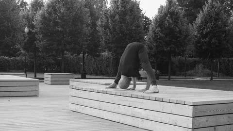 A man doing yoga exercises in the park Stock Footage