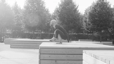 A man doing yoga exercises in the park Stock Footage