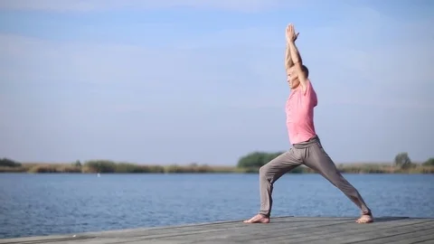 A man doing yoga by the lake Stock Footage 75809719