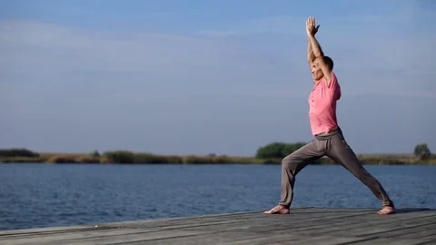 A man doing yoga by the lake Stock Footage 76240452
