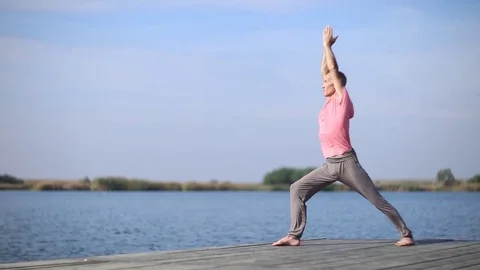 A man doing yoga by the lake Stock Footage 80003657