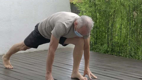 Man doing yoga with mask during coronavirus quarantine Stock Footage 132976280