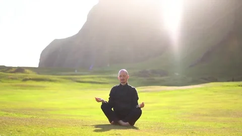 Man doing yoga in nature at sunset Stock Footage 257680661