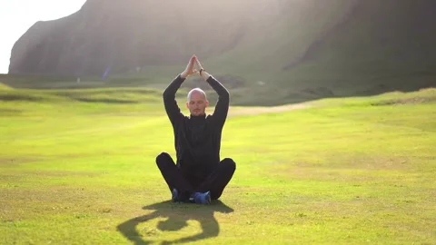 Man doing yoga in nature at sunset Stock Footage 257680754