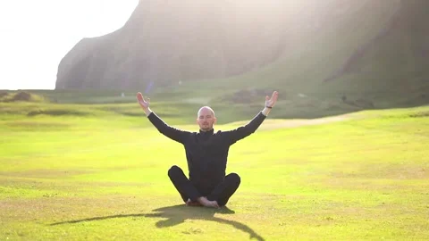 Man doing yoga in nature at sunset Stock Footage 257790736