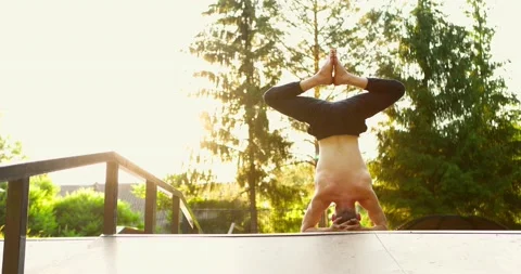 Man doing yoga in open air in summer day morning.Yogi meditating on head on yoga Video stock 156837894