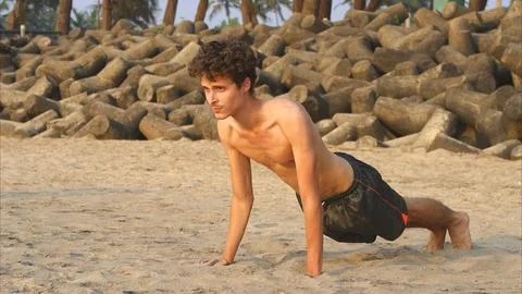 Man doing yoga on the sandy beatch Stock Photos