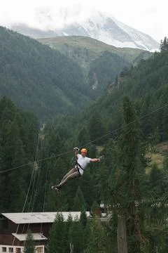 Man doing a zip wire in the mountains in Zermatt Switzerland Stock Photos