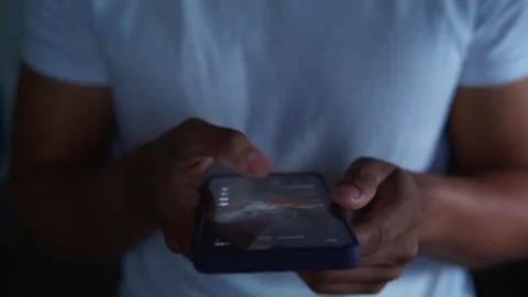 Man doomscrolling on social media feed at night 動画素材 344756626