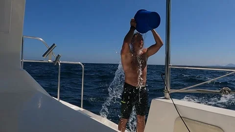 Man dousing himself with water while yachting Stock Footage 294672724