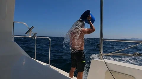 Man dousing himself with water while yachting Stock Footage 294672757