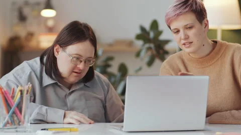 Man with Down Syndrome Learning Laptop with Social Worker Stock Footage 148829235