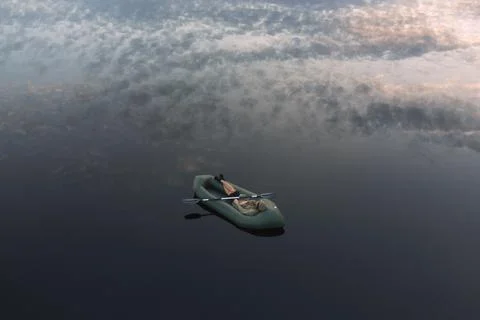 A man dozes in a packraft on the mirror surface of the water Foto stock