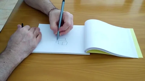 Man Drawing a Abstract Image in a Sketch pad Stock Footage 152070621