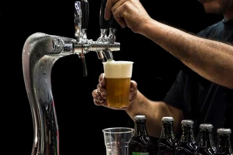Man drawing beer from tap Stock Photos