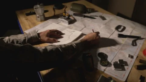 Man drawing map on his rustic table with camping accessories	 Stock Footage 163985987