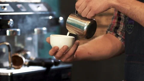 The man drawing the milk over the coffee Stock Footage 87846151