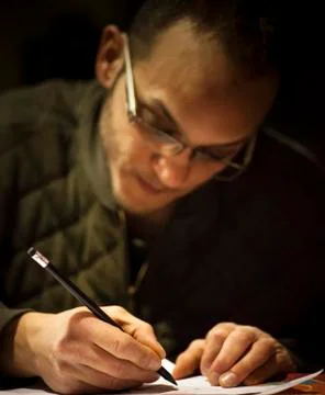 A man is drawing on a paperwork Stock Photos