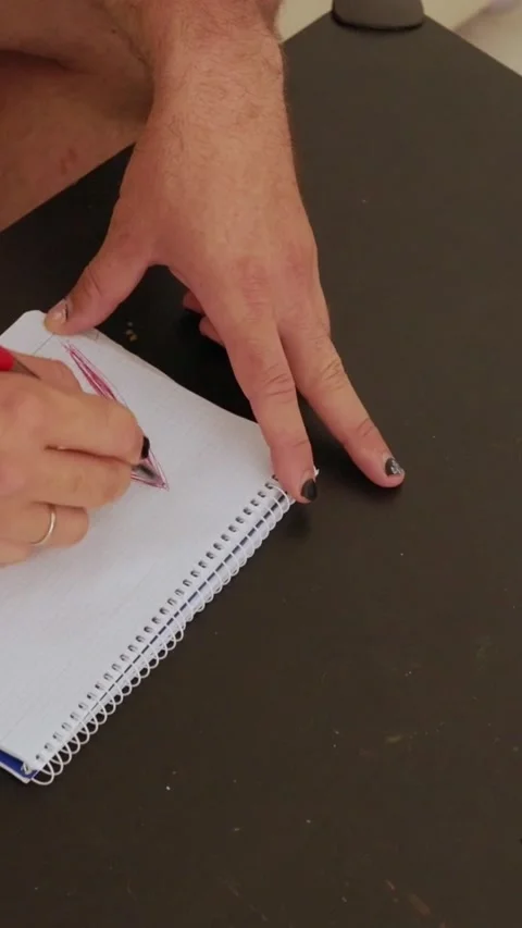 Man drawing zigzag lines on notepad with red pencil Stock Footage 327862450