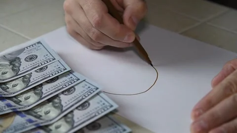 A man draws bitcoin on paper with a felt-tip pen. Stock Footage 145143170
