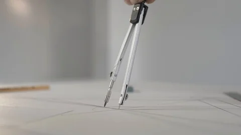 Man draws a circle with compasses on paper Stock Footage 124941302