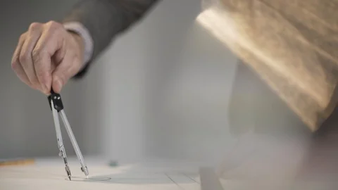 Man draws a circle with compasses on paper Stock Footage 124941325