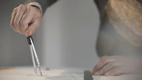 Man draws a circle with compasses on paper Stock Footage 124941709