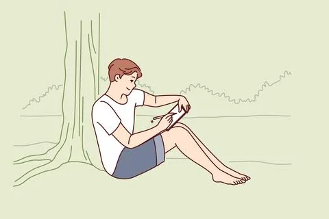 Man draws in electronic tablet sitting on shore of lake and enjoying landscape Illustrazione stock