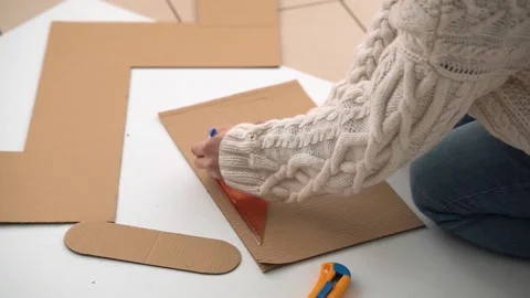 Man draws a line with a pen using a ruler on cardboard Stock Footage 142931285