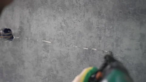 The man draws a line to work with a puncher. Close-up Stock Footage 147077264