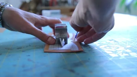 The man draws the pattern of making the bag on the leather.
First, he puts Stock Footage 169142296