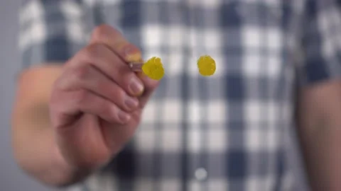 A man draws a sad yellow smiley face on a transparent glass. Drawing with paint Stock-Footage 235636595