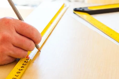 Man draws on a sheet of chipboard Stock Photos