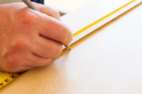 Man draws on sheet of chipboard Stock Photos