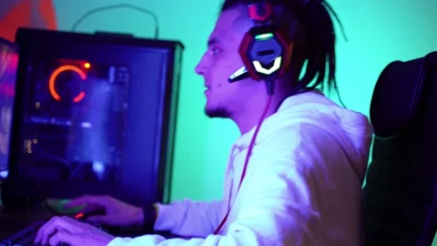 Man with dreadlocks in computer headphones playing a game Vidéo 143374240
