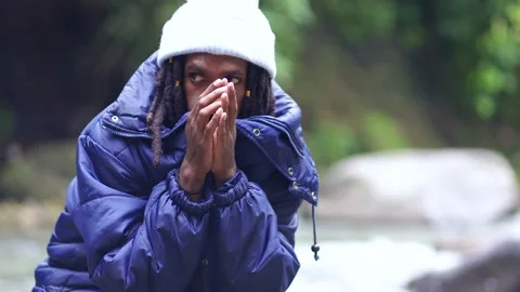 A Man With Dreadlocks Freezing at the Side of a River Stock Footage 208916525
