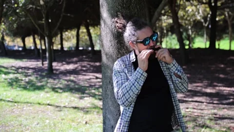 Man with Dreadlocks Ponytail in Sunglasses Playing Harmonica, Mouth Organ Stock Footage 291478584