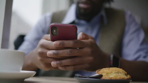 Man with Dreadlocks using Mobile Phone in Cozy coffee shop Setting Stock Footage 312578902