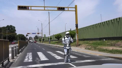 A man dressed and painted as a robot on the street doing an act on a traffic Stock Footage 167370047